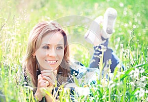 Portrait of a beautiful young woman lying in the grass