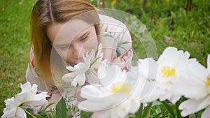 portrait of a beautiful young woman with peonies flowers outdoors.