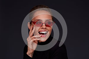 Portrait of beautiful young woman with perfect makeup wearing pink sunglasses.