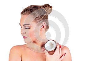 Portrait of beautiful young woman with perfect skin holding a coconut in the studio white background, spa and cosmetics