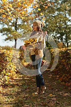Portrait of beautiful young woman posing in autumn park