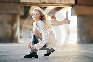 Portrait of beautiful young woman posing on urban street background looking to camera with copy space