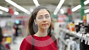 Portrait of a beautiful young woman posingin the background of a store, in a blur. The concept of shopping and consumerism.