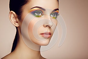 Portrait of beautiful young woman with rainbow make-up