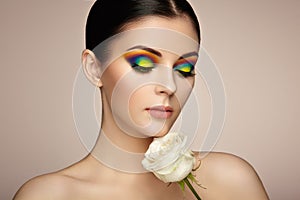 Portrait of beautiful young woman with rainbow make-up