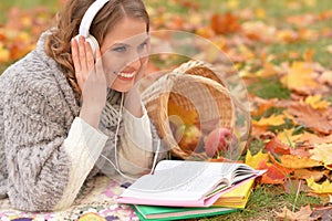 Portrait of beautiful young woman reading in park