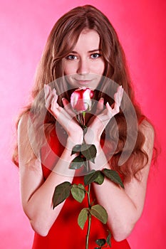 Portrait of a beautiful young woman with a red rose