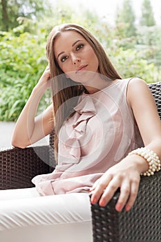 Portrait of beautiful young woman relaxing on chair in park