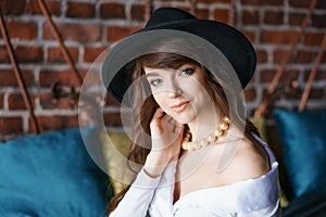 Portrait of a beautiful young woman in retro style in an elegant black hat