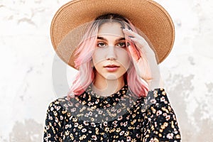 Portrait beautiful young woman with sexy lips with glamorous pink hair in vintage stylish straw hat in fashionable black floral