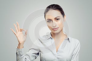 Portrait of beautiful young woman showing okay sign gesture. Face expressions and emotions