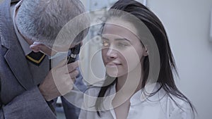 Portrait beautiful young woman sitting in the chair of doctor oculist doing eye test. Professional ophthalmologist