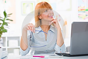 Portrait of beautiful young woman sitting her desk and working at her home