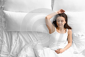 Portrait of beautiful young woman sleeping in large bed
