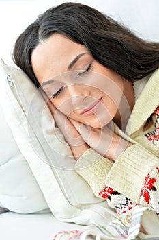 Portrait of beautiful young woman sleeping on sofa at home