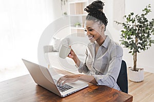 portrait of a beautiful young woman smiling and looking at laptop screen