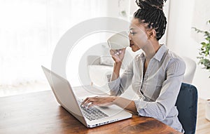 portrait of a beautiful young woman smiling and looking at laptop screen