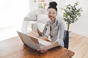 portrait of a beautiful young woman smiling and looking at laptop screen