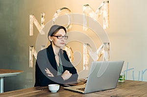 Portrait of a beautiful young woman smiling and looking at laptop screen