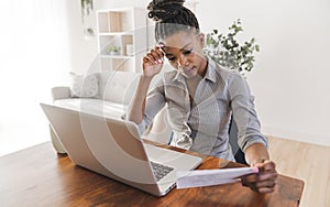 portrait of a beautiful young woman smiling and looking at laptop screen problem with billing