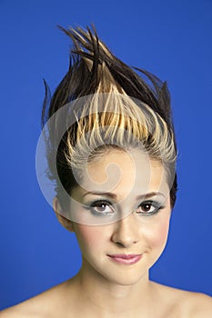 Portrait of a beautiful young woman with spiked hair over colored background