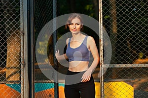 Portrait of a beautiful young woman in sportswear outdoors. Sport fitness model caucasian ethnicity training.