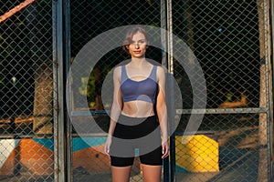 Portrait of a beautiful young woman in sportswear outdoors. Sport fitness model caucasian ethnicity training.