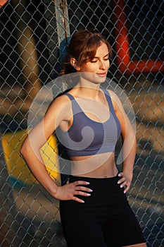 Portrait of a beautiful young woman in sportswear outdoors. Sport fitness model caucasian ethnicity training.