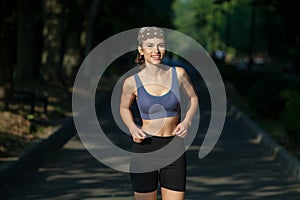 Portrait of a beautiful young woman in sportswear outdoors. Sport fitness model caucasian ethnicity training.