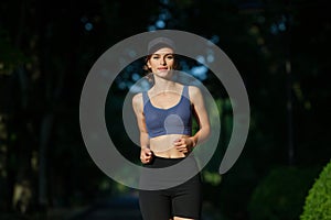 Portrait of a beautiful young woman in sportswear outdoors. Sport fitness model caucasian ethnicity training.