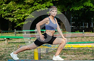 Portrait of a beautiful young woman in sportswear outdoors. Sport fitness model caucasian ethnicity training.