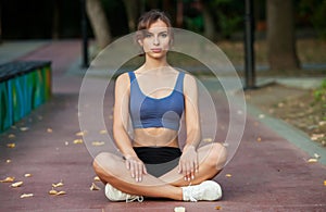Portrait of a beautiful young woman in sportswear outdoors. Sport fitness model caucasian ethnicity training outdoor.