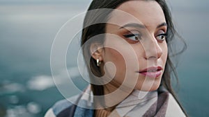 Portrait beautiful young woman standing in front gray gloomy seascape alone.