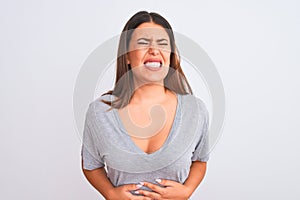 Portrait of beautiful young woman standing over isolated white background with hand on stomach because indigestion, painful