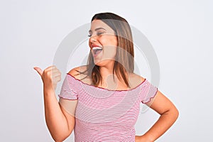 Portrait of beautiful young woman standing over isolated white background smiling with happy face looking and pointing to the side