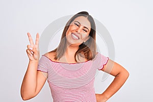 Portrait of beautiful young woman standing over isolated white background smiling with happy face winking at the camera doing