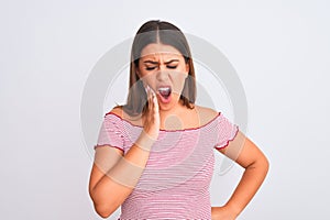 Portrait of beautiful young woman standing over isolated white background touching mouth with hand with painful expression because