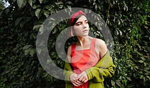 Portrait of beautiful young woman staying in green park garden trees  natural background