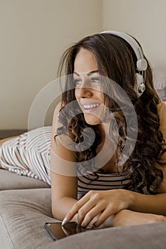 Portrait of beautiful young woman in stylish clothes listing music