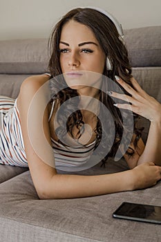 Portrait of beautiful young woman in stylish clothes listing music