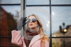 Portrait of beautiful young woman with sunglasses. City lifestyle. Female fashion. Closeup. reflection background