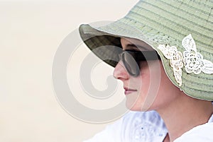 Portrait of a beautiful young woman in sunglasses and green hat