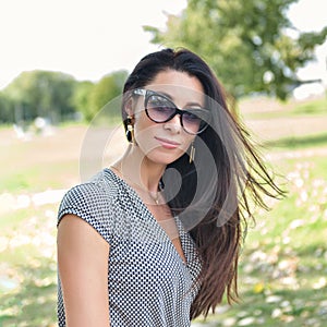 Portrait of a beautiful young woman in sunglasses outdoorin a park