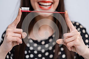 Portrait of beautiful young woman with toothbrush in hands. Healthy white teeth. Dental concept.