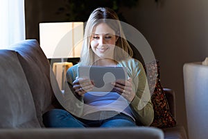 Beautiful young woman using her digital tablet at home.