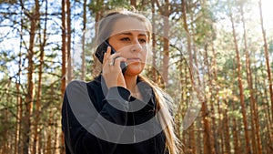 Portrait of beautiful young woman using smartphone in pine forest