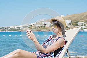 Portrait of beautiful young woman using tablet  on a sea background.Summer holiday