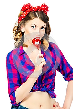 Portrait of beautiful young woman with vintage make-up and hairstyle with lollipop