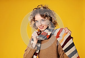 Portrait of beautiful young woman in warm clothes on color background