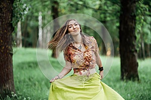 Portrait of Beautiful young woman wearing bohostyle clothes posing in the rays of the evening sun, sunset. Boho style
